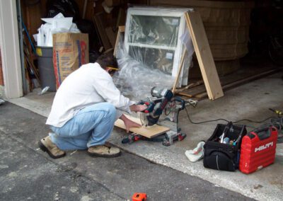 man working in garage to fix egress window