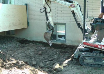 Digging Around The Foundation of A Home To Repair The Concrete